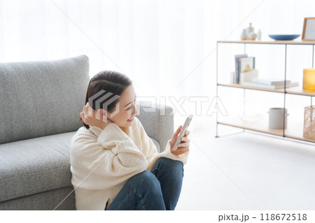 リビングでスマホを操作する女性 118672518