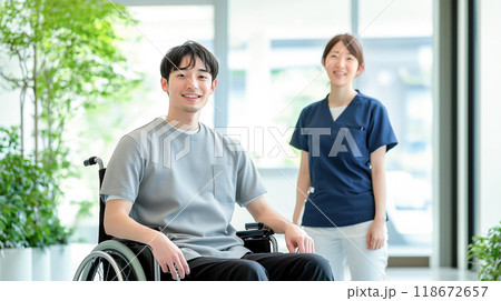 車椅子に乗る若い男性と女性ヘルパー 車椅子に乗る若い男性と女性ヘルパー 118672657