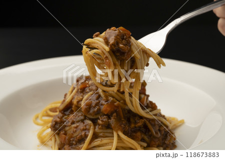 ミートソススパゲティ パスタをフォークで巻いて持ち上げる ミートソススパゲティ パスタをフォークで巻いて持ち上げる 118673883