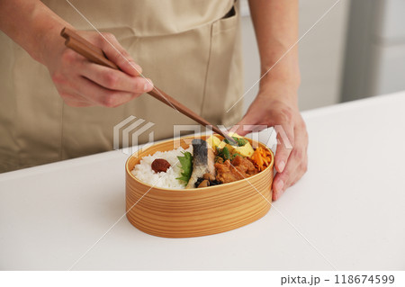 お母さんがキッチンでお弁当を作るシーン 118674599