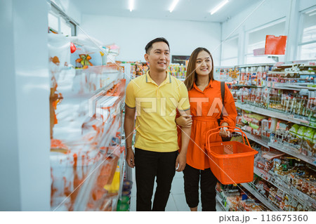 Asian husband and wife couple walking beside a shelf Asian husband and wife couple walking beside a shelf 118675360