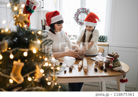 Mother and daughter baking together during Christmas holiday season 118675361