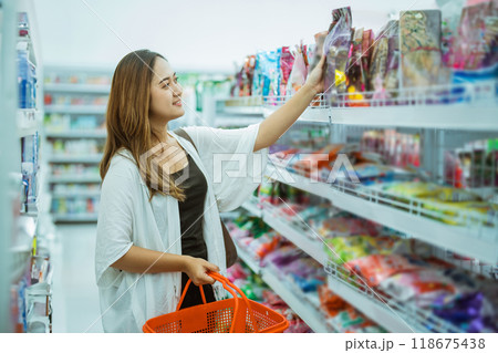 beautiful Asian woman looking at items on the top shelf while shopping beautiful Asian woman looking at items on the top shelf while shopping 118675438