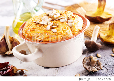 Vegetarian autumn pumpkin cream soup with mushrooms and seeds 118675680