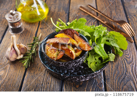 Bowl with baked potatoes on wooden background Bowl with baked potatoes on wooden background 118675719