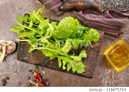 Fresh arugula leaves, rucola on wooden board Fresh arugula leaves, rucola on wooden board 118675724