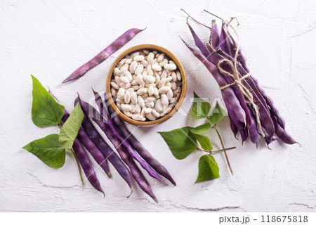 Uncooked dried white haricot beans in bowl n on table. Heap of legume haricot bean background Uncooked dried white haricot beans in bowl n on table. Heap of legume haricot bean background 118675818