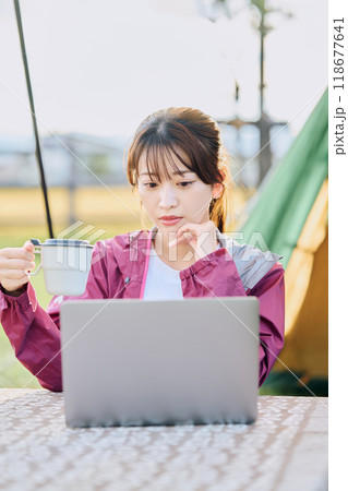 キャンプ場でワーケーションをする女性 118677641