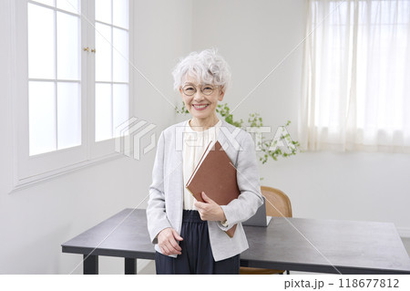 オフィスに立つ笑顔の高齢者のビジネスウーマン 118677812