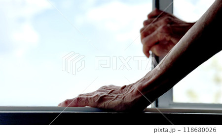 窓を開ける高齢女性の手 118680026