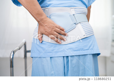 Asian lady patient wearing back pain support belt for orthopedic lumbar with walker. 118680251