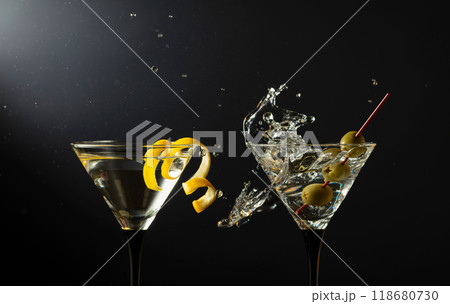 Classic dry martini cocktails with green olives and lemon peel on a black background. 118680730
