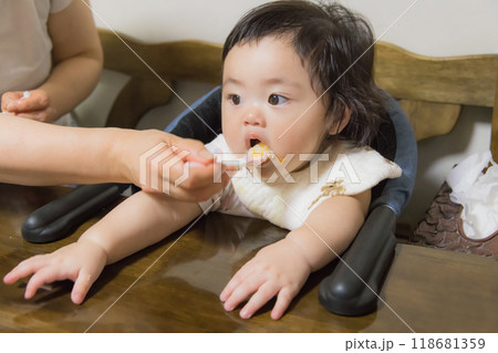 【離乳食を食べる髪を結んだ赤ちゃん】 【離乳食を食べる髪を結んだ赤ちゃん】 118681359