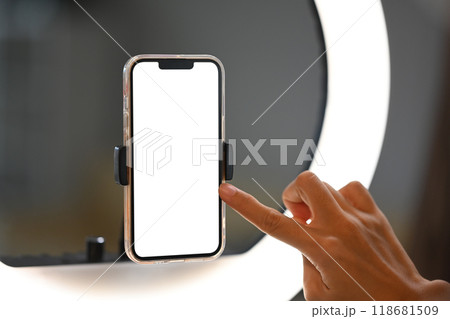 Close up shot woman setting up a smartphone on a ring light for video recording or live streaming Close up shot woman setting up a smartphone on a ring light for video recording or live streaming 118681509