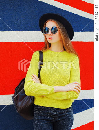 Portrait of beautiful young woman posing on english flag wall background Portrait of beautiful young woman posing on english flag wall background 118682131
