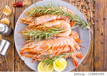 Plate with tasty boiled shrimps, rosemary and lime 118682400