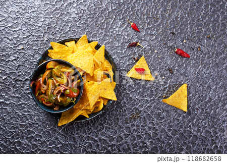 Single big black plate of yellow corn tortilla nachos chips with salsa sauce 118682658