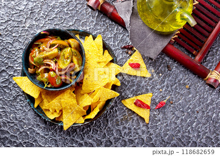 Single big black plate of yellow corn tortilla nachos chips with salsa sauce 118682659