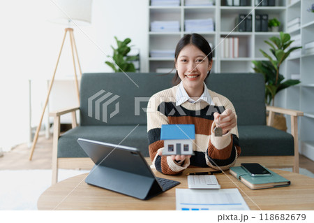 woman holds the key to her new house, securing a loan to manage the financial aspects of her home ownership, balancing finance and the responsibilities of a housing loan woman holds the key to her new house, securing a loan to manage the financial aspects of her home ownership, balancing finance and the responsibilities of a housing loan 118682679