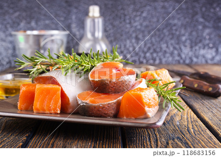 Salmon. Fresh raw salmon fish fillet with cooking ingredients, herbs and lemon on dark background Salmon. Fresh raw salmon fish fillet with cooking ingredients, herbs and lemon on dark background 118683156