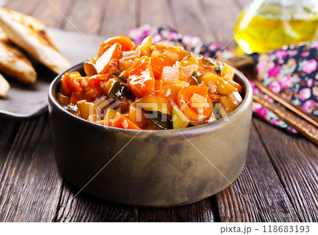 Summer Vegetable spicy stew of zucchini, potatoes, peppers, onions, tomatoes and eggplant in a bowl on the table. Summer Vegetable spicy stew of zucchini, potatoes, peppers, onions, tomatoes and eggplant in a bowl on the table. 118683193