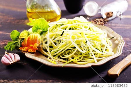 Raw zucchini noodles on plate. Zucchini spaghetti in metal bowl. Raw zucchini noodles on plate. Zucchini spaghetti in metal bowl. 118683485