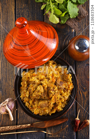 Uzbek cuisine food pilaf, rice with carrots, vegetable oil, raisins 118683504