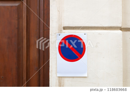 No parking sign on a concrete wall near door. Red and blue no parking sign No parking sign on a concrete wall near door. Red and blue no parking sign 118683668