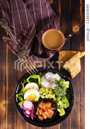 Rice with red fish, green beans and broccoli in a black plate. Diet. 118683699