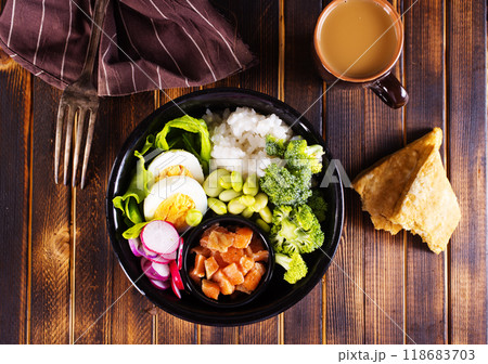 Rice with red fish, green beans and broccoli in a black plate. Diet. Rice with red fish, green beans and broccoli in a black plate. Diet. 118683703