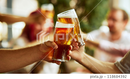 Toast to victory. Fans celebrate with their beers, blurred crowd behind them buzzing with shared emotion and energy. Selective focus. 118684392