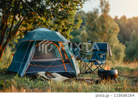 Camping outdoors with lots of sunlight. tent, chairs, a tent BBQ rack, and more 118686164