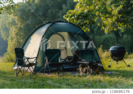 Camping outdoors with lots of sunlight. tent, chairs, a tent BBQ rack, and more 118686176