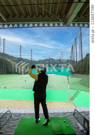 山の中のゴルフ練習場でスイングをするシニア男性 118687390