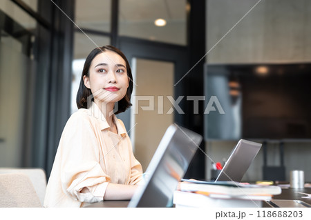 パソコン作業の合間に窓からの景色を見ながら穏やかな表情を浮かべる女性 パソコン作業の合間に窓からの景色を見ながら穏やかな表情を浮かべる女性 118688203