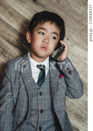 スーツ姿でスマートフォンを操作している子ども 118688327