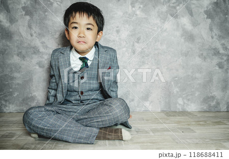 スーツ姿で座っている5歳児 スーツ姿で座っている5歳児 118688411