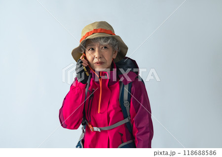 怯えてスマホで通話する登山服のシニア女性 怯えてスマホで通話する登山服のシニア女性 118688586