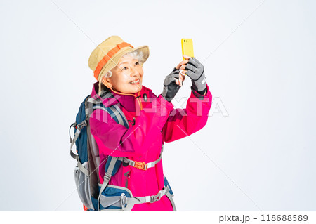 怯えてスマホで通話する登山服のシニア女性 怯えてスマホで通話する登山服のシニア女性 118688589
