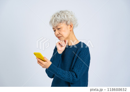 スマホを使いながらがっかりするシニア女性 スマホを使いながらがっかりするシニア女性 118688632