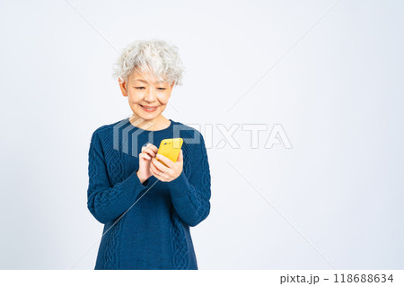 笑顔でスマホを使うシニア女性 118688634