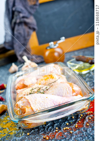 Raw chicken drumsticks with seasonings in glass plate. Chicken legs ready to cook. Raw chicken drumsticks with seasonings in glass plate. Chicken legs ready to cook. 118688717