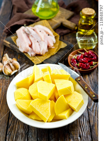 raw potato and chicken on wooden table 118688797