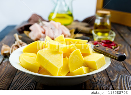 raw potato and chicken on wooden table 118688798