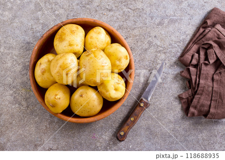 bowl with raw potatoes on a table bowl with raw potatoes on a table 118688935