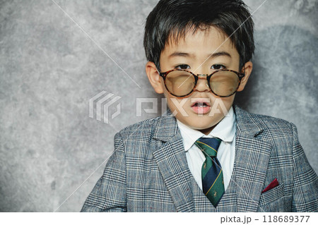 スーツ姿でサングラスをかけて遊んでいる子ども スーツ姿でサングラスをかけて遊んでいる子ども 118689377
