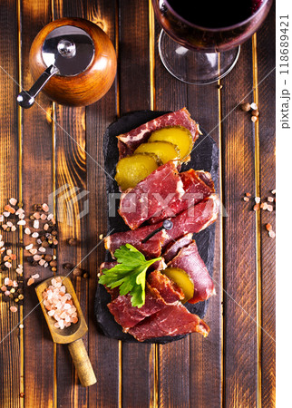 Flat slices of square sandwich ham with herbs. Dark background. Top view. Copy space. 118689421