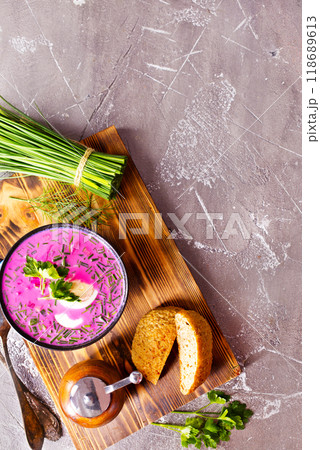A portion of beetroot soup with egg, dill, parsley and cucumber on a gray background. A portion of beetroot soup with egg, dill, parsley and cucumber on a gray background. 118689613