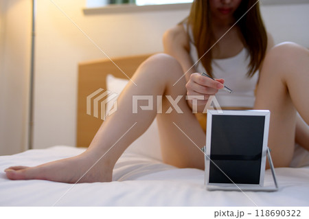 VIOデリケートゾーン股間のセルフケアをする若い女性 鏡を見ながらピンセットで毛抜き ネガティブ暗め VIOデリケートゾーン股間のセルフケアをする若い女性 鏡を見ながらピンセットで毛抜き ネガティブ暗め 118690322