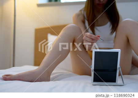 VIOデリケートゾーン股間のセルフケアをする若い女性 鏡を見ながらピンセットで毛抜き 暗め寒色緑 VIOデリケートゾーン股間のセルフケアをする若い女性 鏡を見ながらピンセットで毛抜き 暗め寒色緑 118690324